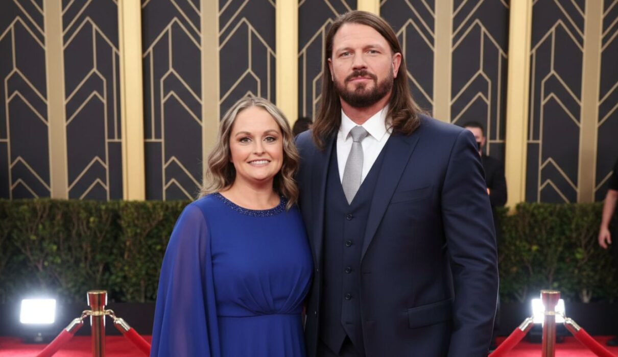 Elegant couple posing on the red carpet at a formal event, dressed in stylish evening attire.