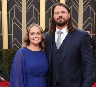 Elegant couple posing on the red carpet at a formal event, dressed in stylish evening attire.