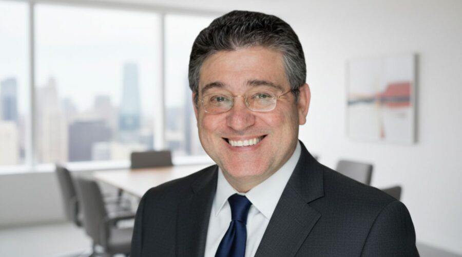 Smiling businessman in formal suit standing in a modern office with city view background